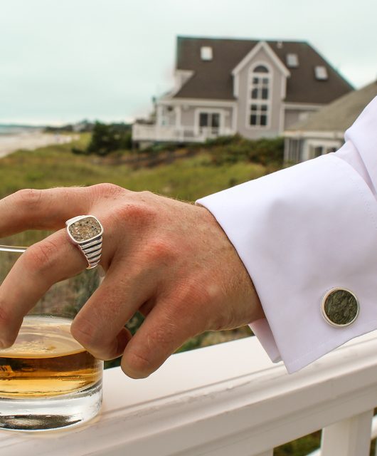 man holding a drink with cufflink gifts this season