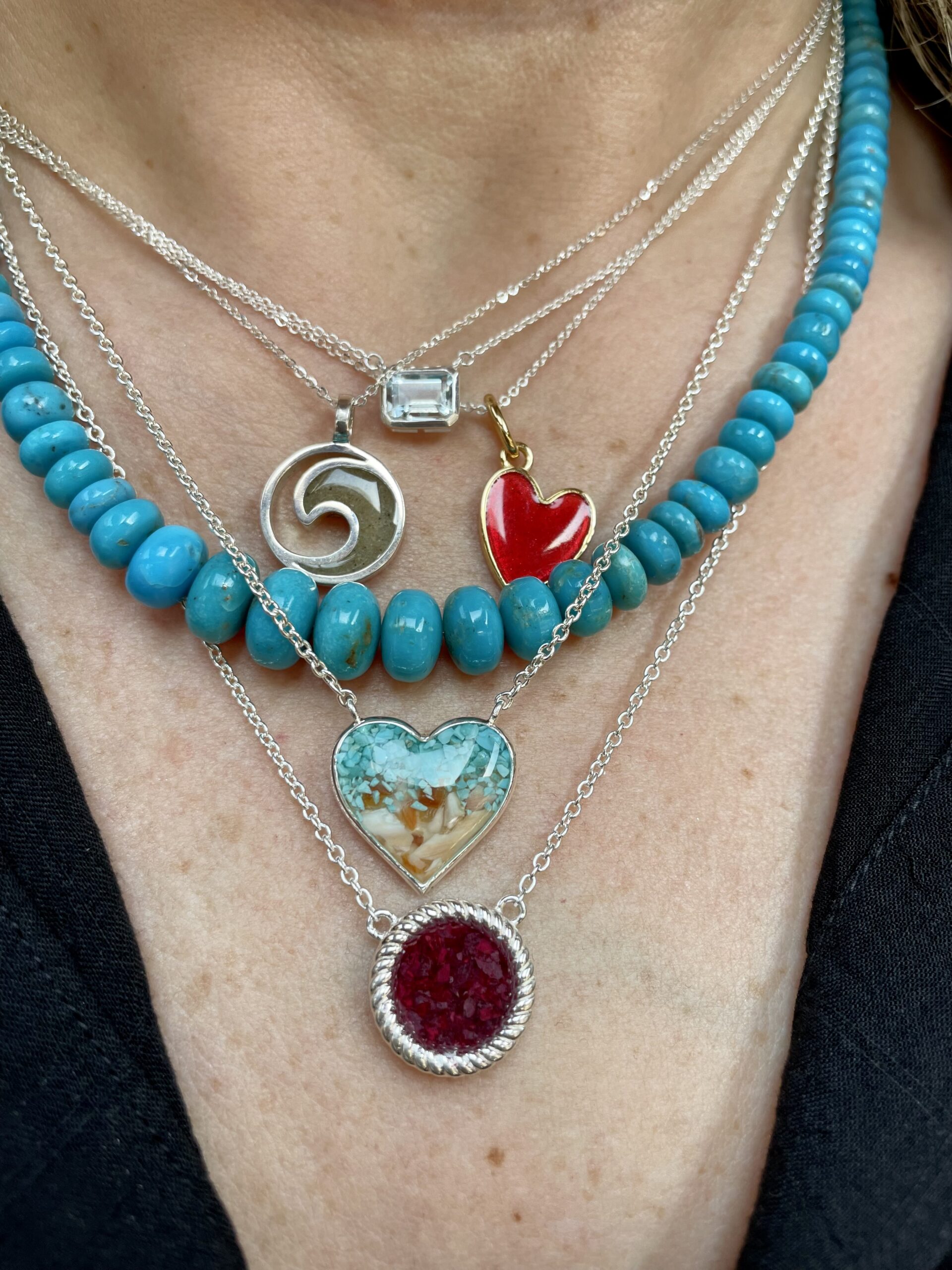 Colorful jewelry and symbolic necklaces layered on neck, turquoise jewelry, close-up.