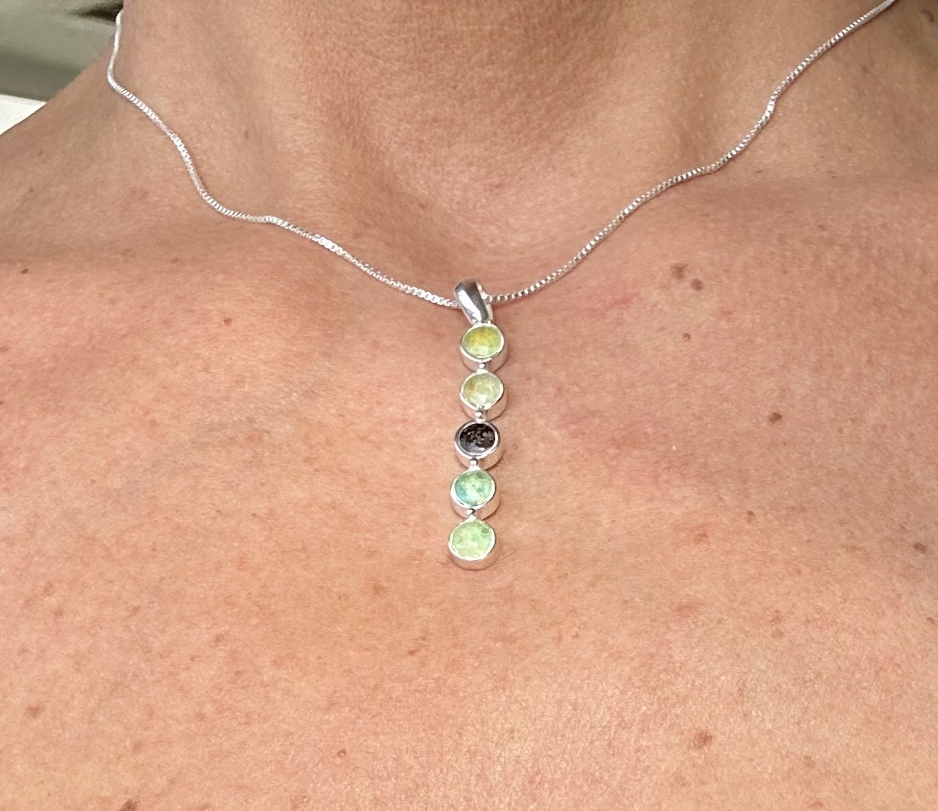 Close-up of Dune Jewelry's Endless Summer Vertical Bar Necklace with 5 sand, shell, and sea glass elements.