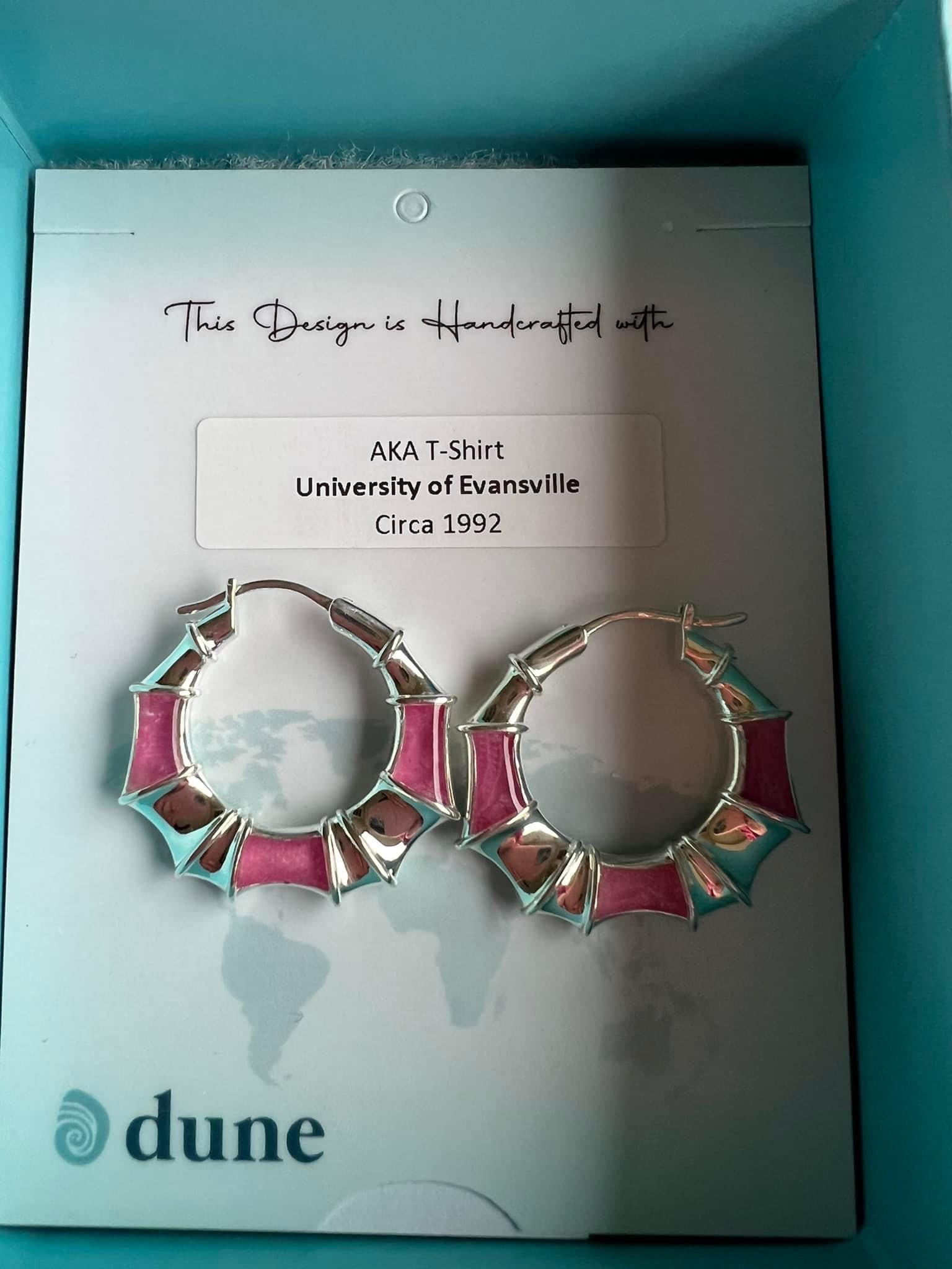 Circular pink and silver hoop earrings from Dune Jewelry lying in box.