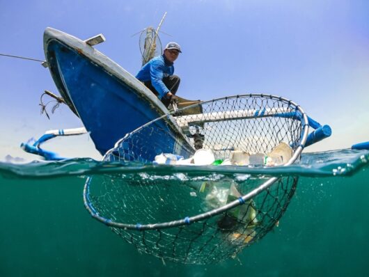 Image of 4ocean crew recovering ocean plastic with a net.