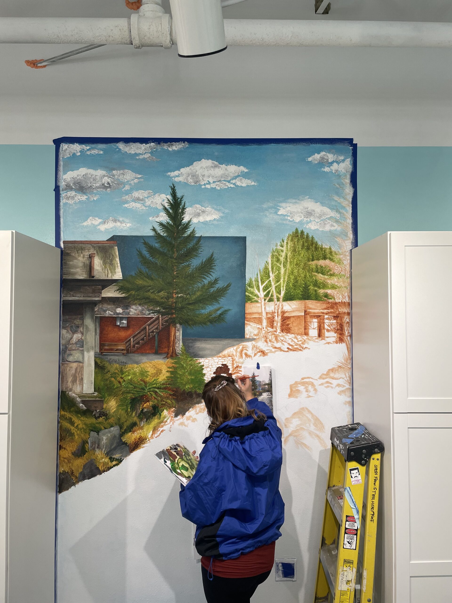 Sarah painting Dune Jewelry's Dune Ketchikan store mural.