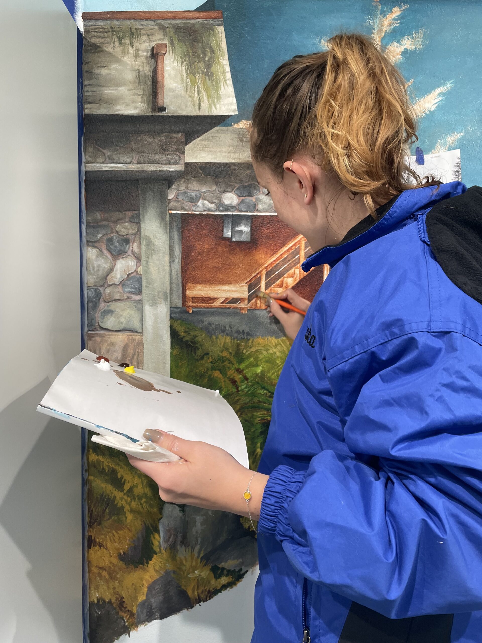 Sarah painting Dune Jewelry's Dune Ketchikan store mural.