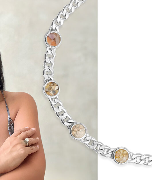 Woman poses in selfie wearing her Traveler Bracelet by Christine Kesteloo, a personalized sterling silver bracelet with sand, shells, and Earth elements from around the world.
