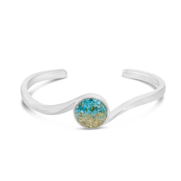 Sterling silver cuff bracelet with wave-inspired textured silver and round sand and turquoise setting just smaller than a dime in the center.
