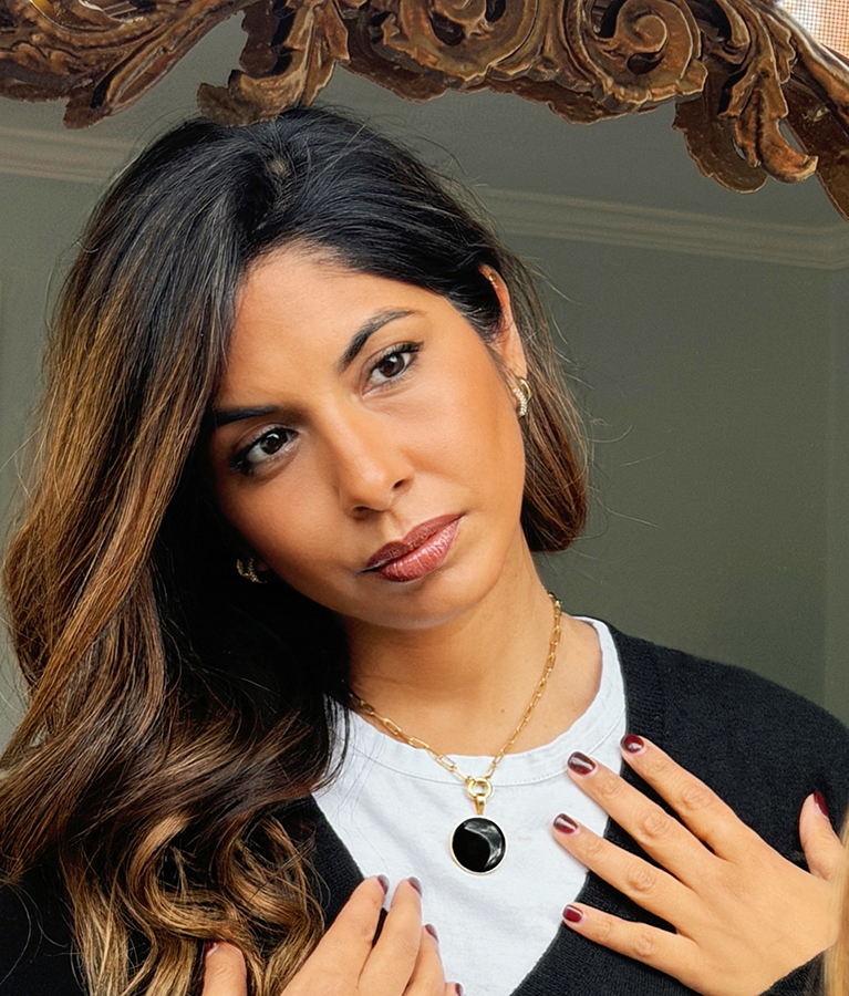 Sheena Melwani wearing a personalized necklace handcrafted with meaningful sand and earth elements.
